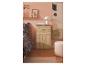 Armoire en bois avec tiroir et portes, dans une chambre rose.