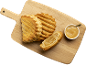 Chaussons aux pommes dorés et bol de compote de pommes sur une planche en bois.