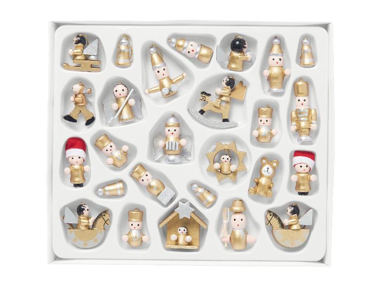 Assortiment d'ornements de Noël en bois dorés et argentés dans une boîte blanche.