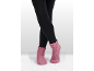 Jambes en leggings noirs et chaussettes-chaussons roses tricotées.
