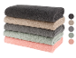 Une pile de serviettes de bain de couleurs neutres.