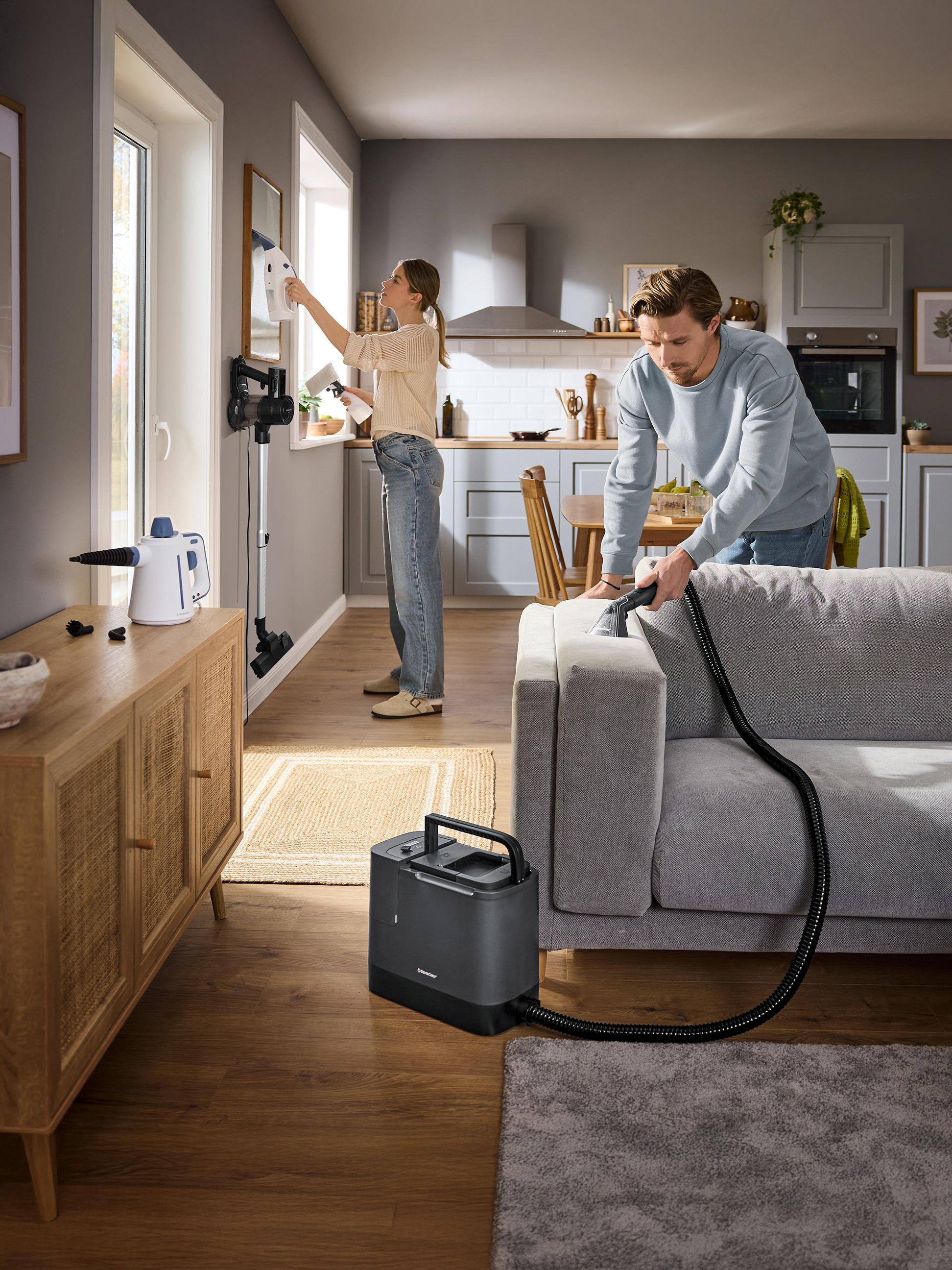 Couple nettoyant la maison avec un nettoyeur de vitres et un nettoyeur textile SilverCrest.