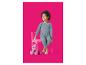 Fille en pyjama bleu à nœuds, assise sur une chaise rose avec un ours en peluche