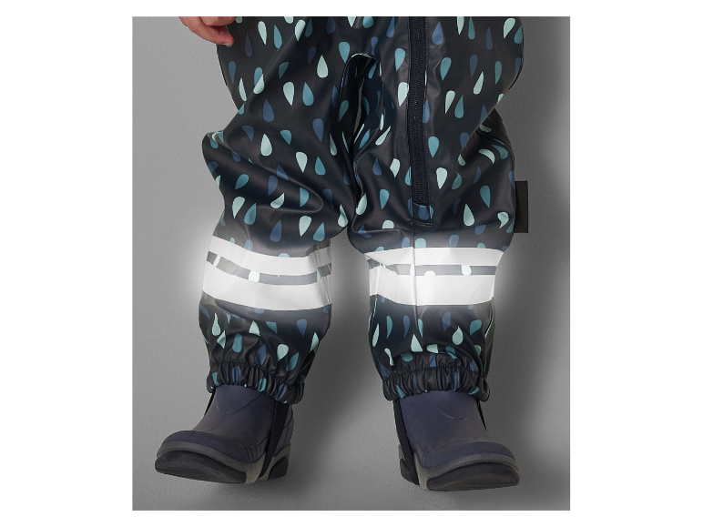 Salopette imperméable pour enfant, motif gouttes et bandes réfléchissantes.