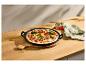 Pizza aux légumes dans une poêle en fonte noire sur une table en bois avec un torchon en lin.