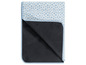 Une couverture de pique-nique bleue à pois blancs avec un dessous imperméable.