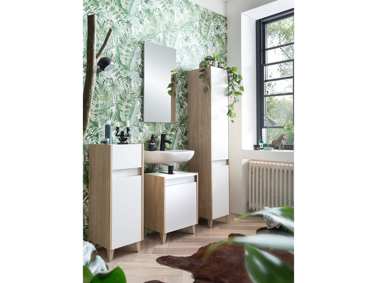 Une salle de bain avec un lavabo, un miroir et deux armoires de rangement.