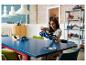 Une femme assemble une voiture de sport LEGO Ford GT bleue sur une table.