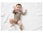 Bébé sur une couverture blanche portant un body beige.