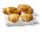 Saucisses en croûte, rouleaux de pâte feuilletée dorés avec des saucisses, parsemés de graines de sésame.