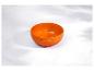 Bol en céramique orange sur une surface en marbre blanc avec des ombres douces.