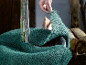 Main enveloppant un jeune arbre de toile de jute verte pour la protection hivernale.