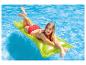 Une femme se prélasse sur une bouée verte dans une piscine.