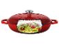 Cocotte rouge avec couvercle, coupe transversale montrant des spaghettis de courgette, tomates et pignons.