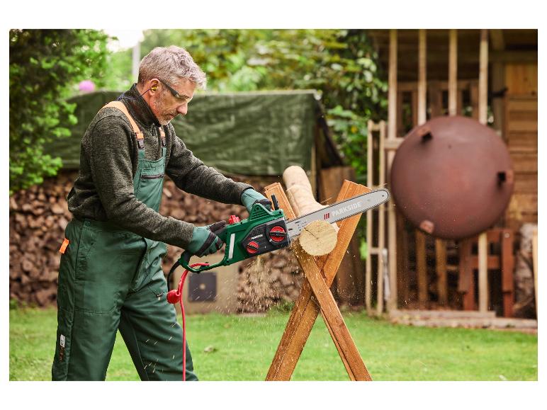 Un homme utilise une tronçonneuse Parkside pour couper du bois.