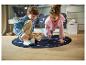 Deux enfants jouent sur un tapis rond à thème spatial.