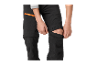 Enfant ajustant un pantalon softshell avec fermetures éclair aux genoux.