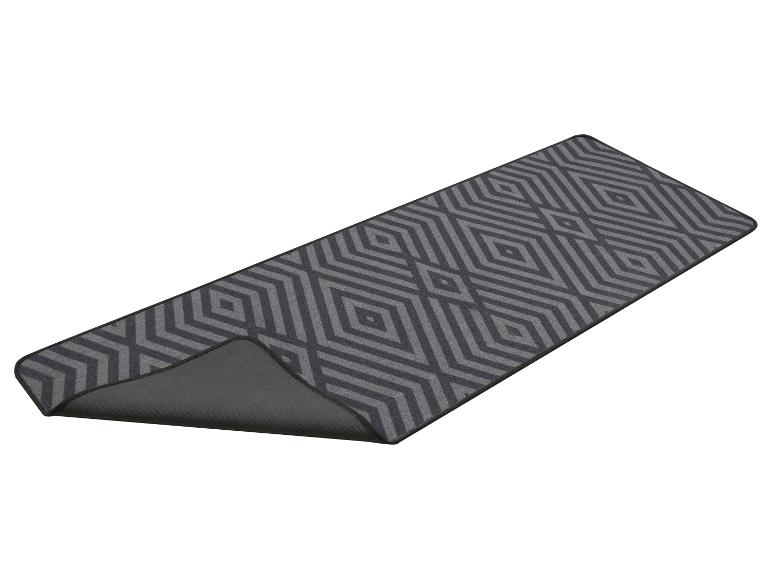 Tapis de couloir avec motif géométrique de losanges gris, avec le dessous antidérapant visible.