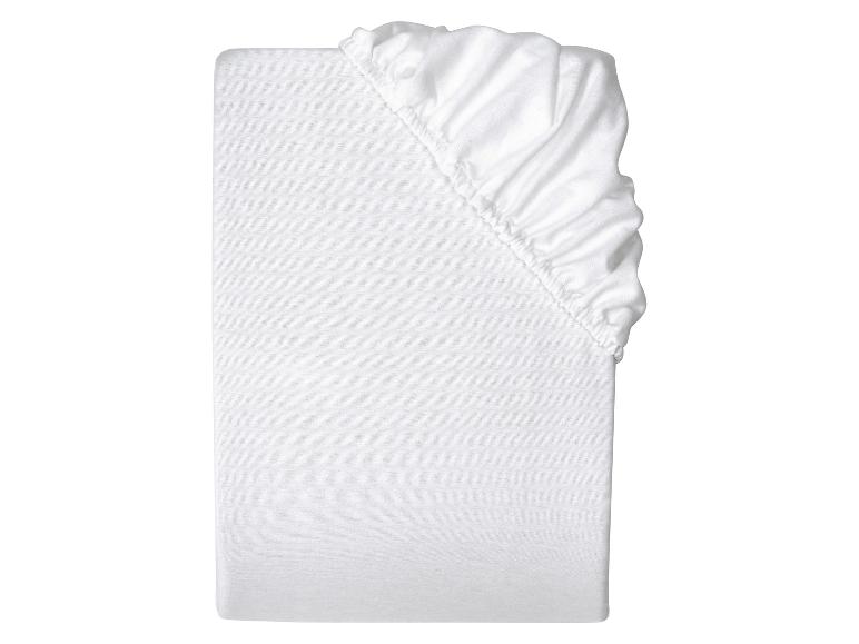 Drap-housse blanc, plié, sur fond blanc
