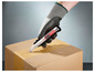 Une main portant un gant de sécurité ouvre un carton avec un cutter Stanley.