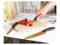 Deux couteaux dorés Russell Hobbs sur une planche à découper en bois.