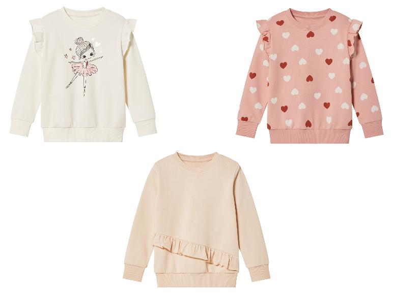 Trois pulls pour filles avec des volants: un avec un imprimé ballerine, un avec des coeurs et un uni.