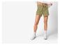 Shorts de sport vert clair pour femmes et baskets blanches.