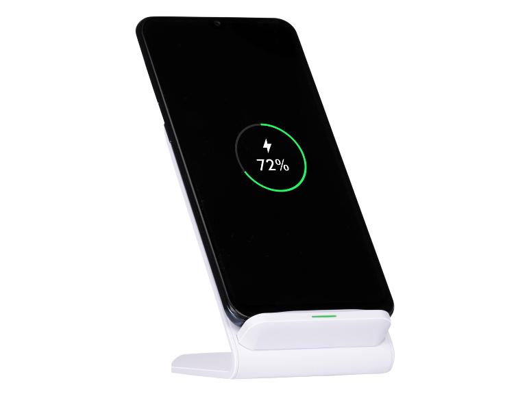 Smartphone noir sur un support de charge sans fil blanc