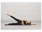 Une femme en leggings noirs et un soutien-gorge de sport est allongée sur un tapis de yoga.