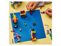 Un enfant construit avec des briques LEGO colorées sur une plaque de base bleue.