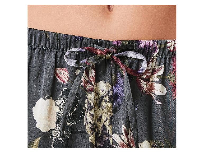 Gros plan de la section médiane d'une personne portant un pantalon de pyjama à imprimé floral avec cordon de serrage.