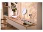Coiffeuse avec miroir LED, pinceaux de maquillage et cosmétiques, avec plante et stores en arrière-plan.