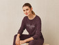 Une femme portant un sweat-shirt marron foncé avec l'inscription 'New York City Manhattan Island'.