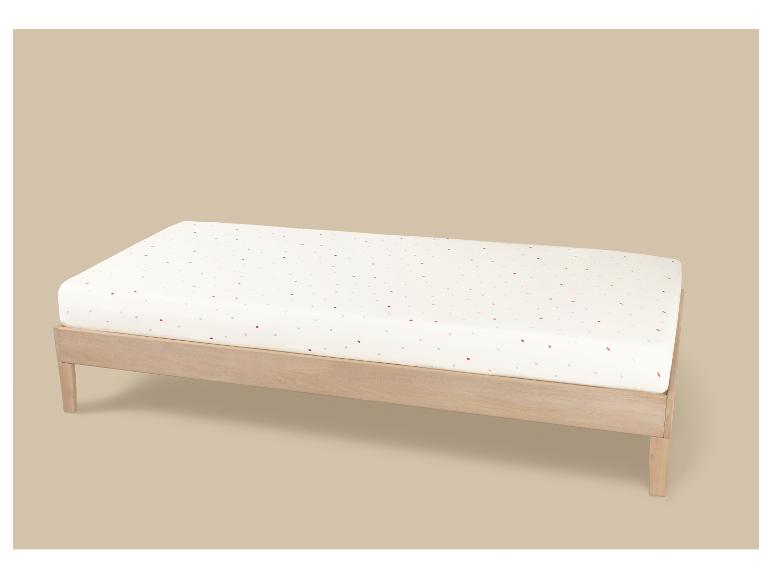 Table à langer en bois avec matelas blanc à pois colorés.