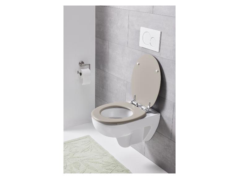 Des toilettes avec un abattant de toilette beige et une chasse d'eau encastrée.