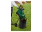 Personne dans le jardin utilisant un broyeur de jardin vert avec un sac de collecte noir.