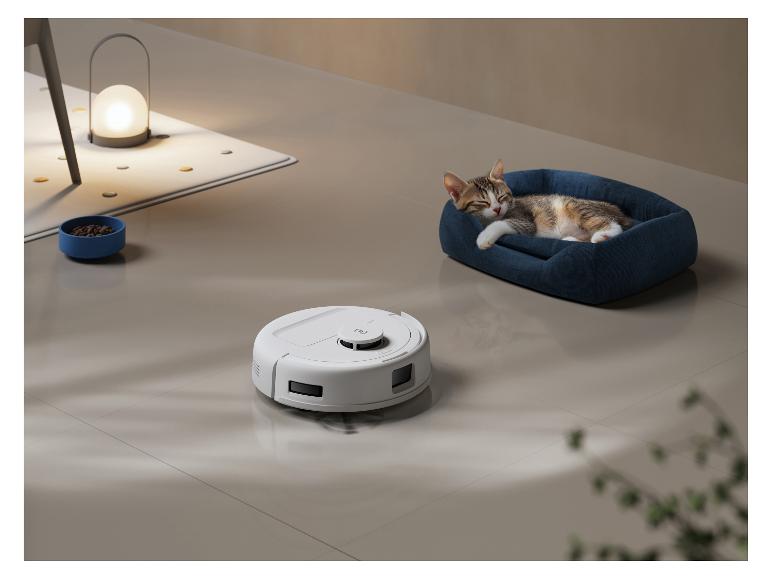 Robot aspirateur blanc sur le sol avec un chat endormi dans un lit bleu.