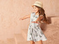 Une fille portant une robe d'été à fleurs et un chapeau de paille.
