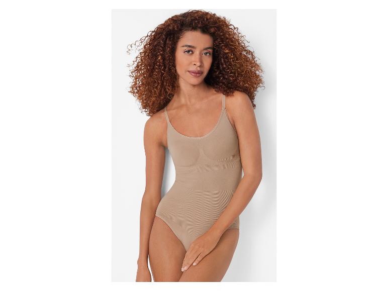 Une femme aux cheveux bouclés porte un body gainant couleur chair.