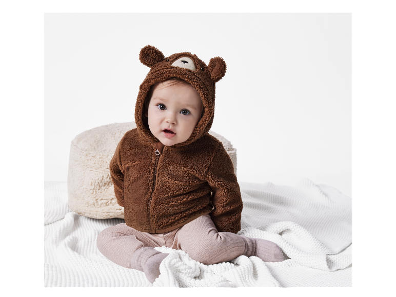 Bébé adorable dans une combinaison en peluche marron ours.