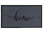 Un paillasson gris avec une bordure noire et le mot 'home' en calligraphie.