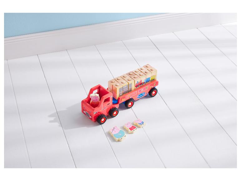 Jouet camion en bois Peppa Pig avec blocs de construction et figurines sur un sol blanc.