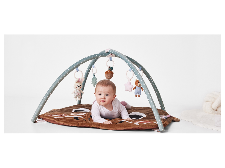 Bébé allongé sur un tapis de jeu avec un auvent.