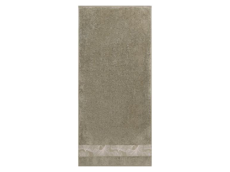 Serviette de toilette kaki avec un motif de feuilles blanches sur l'ourlet.
