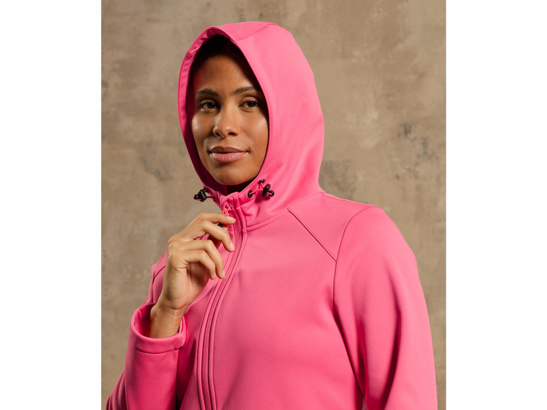 Une femme porte un sweat-shirt à capuche rose.