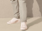 Pantalon beige avec des baskets blanches.