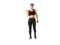 Femme en vêtements de sport noirs utilisant des haltères.