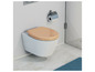 Des toilettes blanches avec un siège de toilette beige dans une salle de bain.