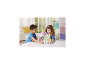 Deux enfants jouent avec un château jouet et des figurines d'animaux sur une table blanche.
