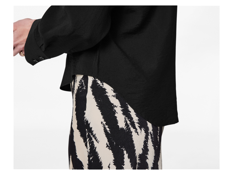 Chemise noire à manches longues et jupe zébrée noir et blanc.